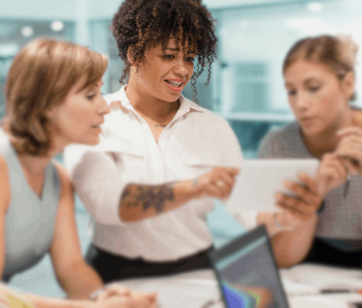 Three women looking at a tablet device